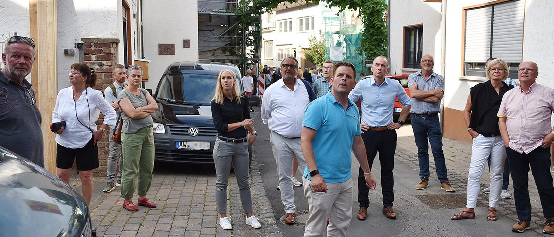 Bei einem Rundgang durch Dernau erklärte Martin Schell (Bildvordergrund), Vorstandsvorsitzender von 'Zukunft Mittelahr', den Stand des Wiederaufbaus und auch im Detail, was gut läuft und wo es hängt ¿ links hinter ihm Ralf Hellrich, Hauptgeschäftsführer der Handwerkskammer (HwK) Koblenz zusammen mit ISB-Vorstand Dr. Ulrich Link (rechts).